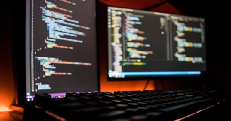 Two computer monitors displaying lines of code, symbolizing the advanced technology behind Loopio's proposal automation.